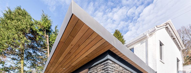 modern extension, cedar clad and glazed sliding doors, terrace with glass balustrade in Lake District